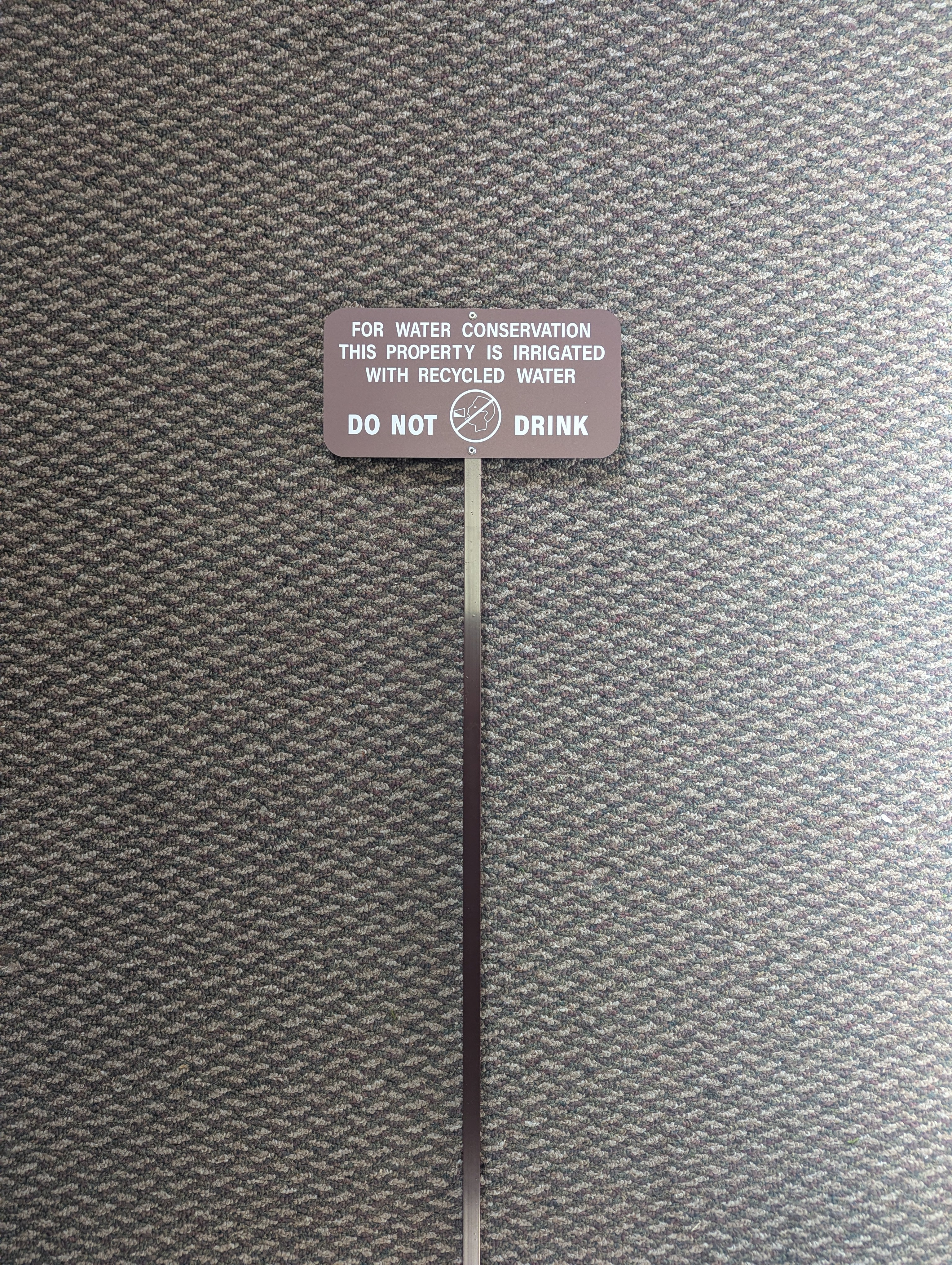 brown recycled water sign used to identify landscape areas using recycled water in Irvine, California.